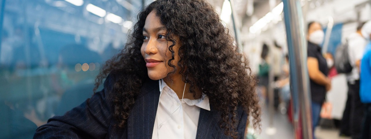 Person smiling looking left outside window of train