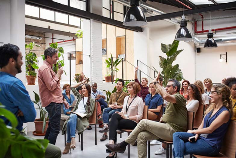 man standing and speaking to an audience at an event