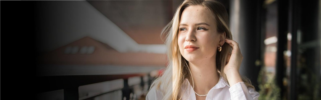 Person smiling with bike in urban setting