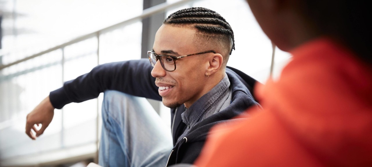 student sitting on stairs smiling