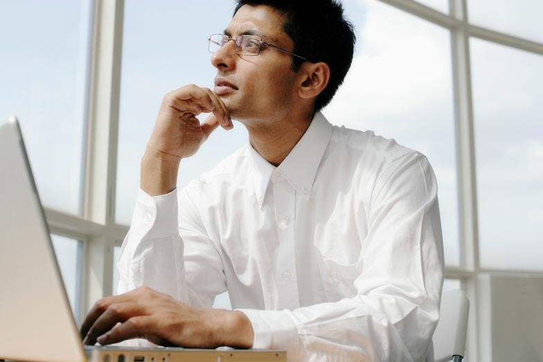 man with laptop looking thoughtful