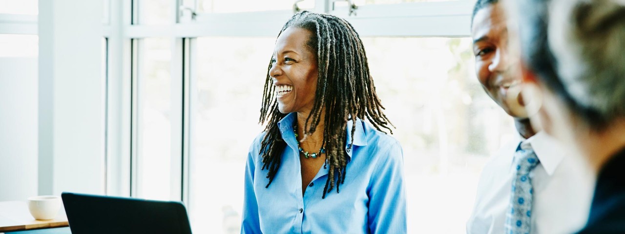 woman laughing with colleagues in an office