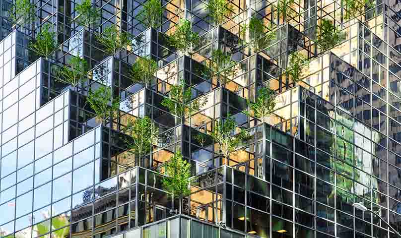 Person smiling with bike in urban setting