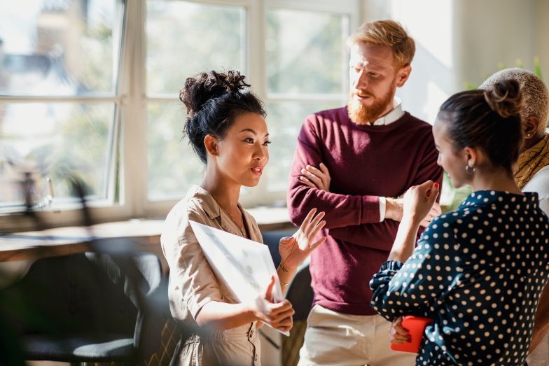 young business person talking to three colleagues
