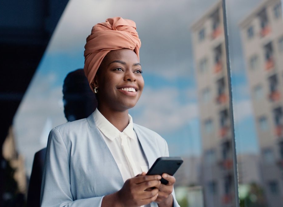 Happy business person with mobile phone outside