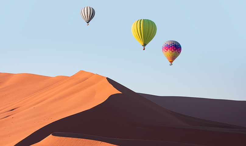 balloons flying over a desert