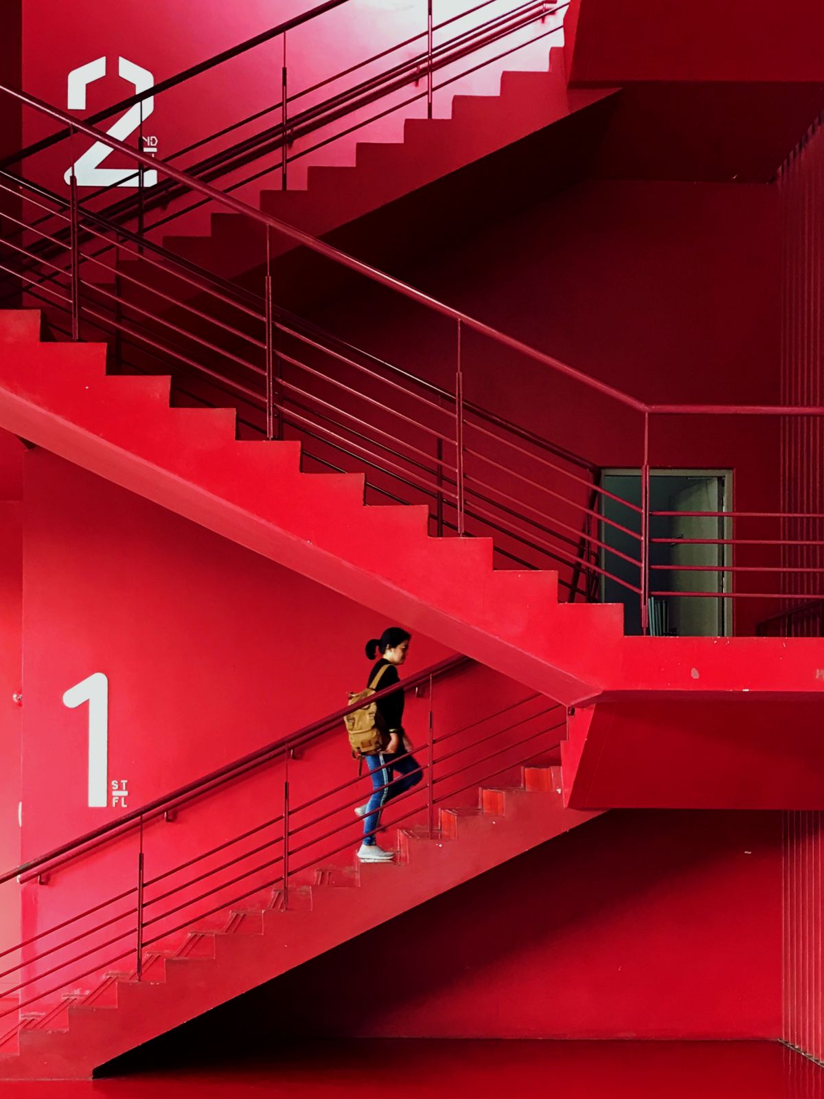 person climbing red staircase