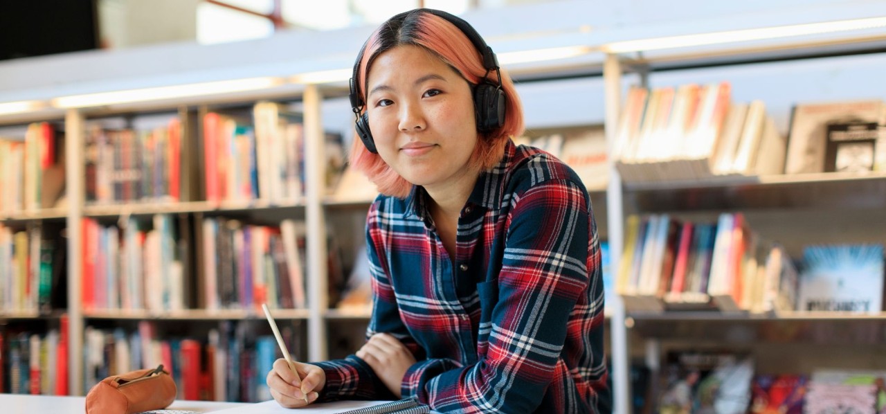 person studying in library with headphones on