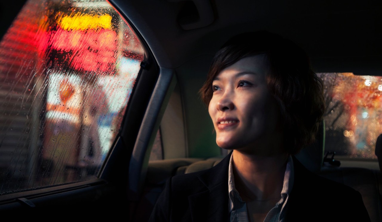 smiling person look out of a car window