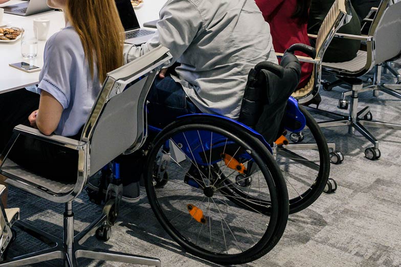 person sitting in wheelchair in conference room