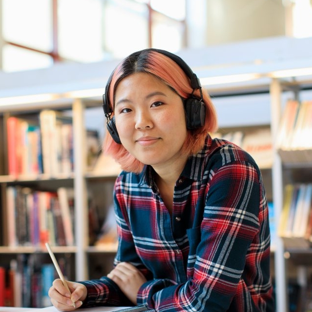 student wearing headphones in library
